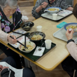 食事風景。入居者が複数の食卓で食事をしている様子